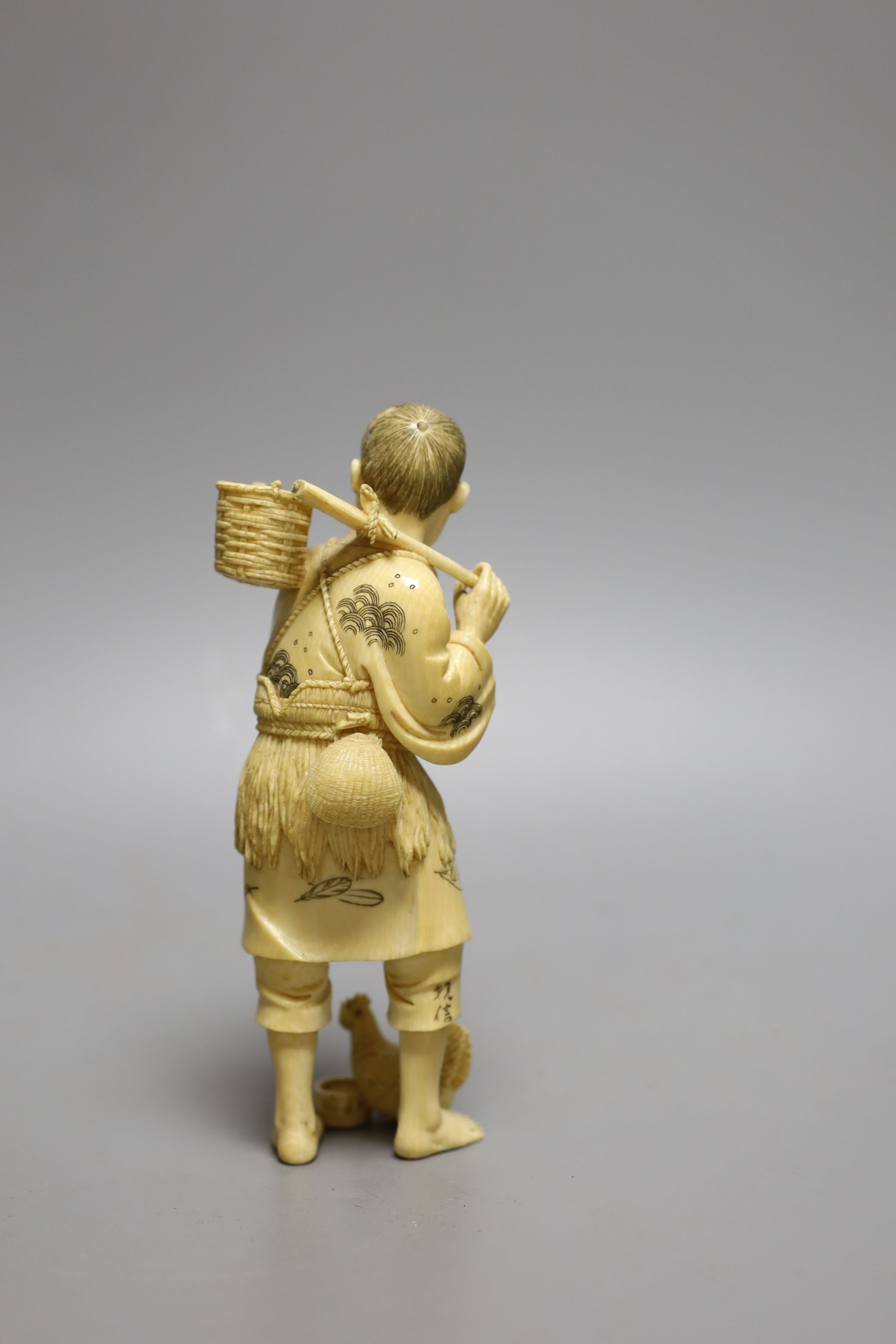 A Japanese ivory okimono of a fisherman and a chicken, Meiji period, signed, 15cm tall